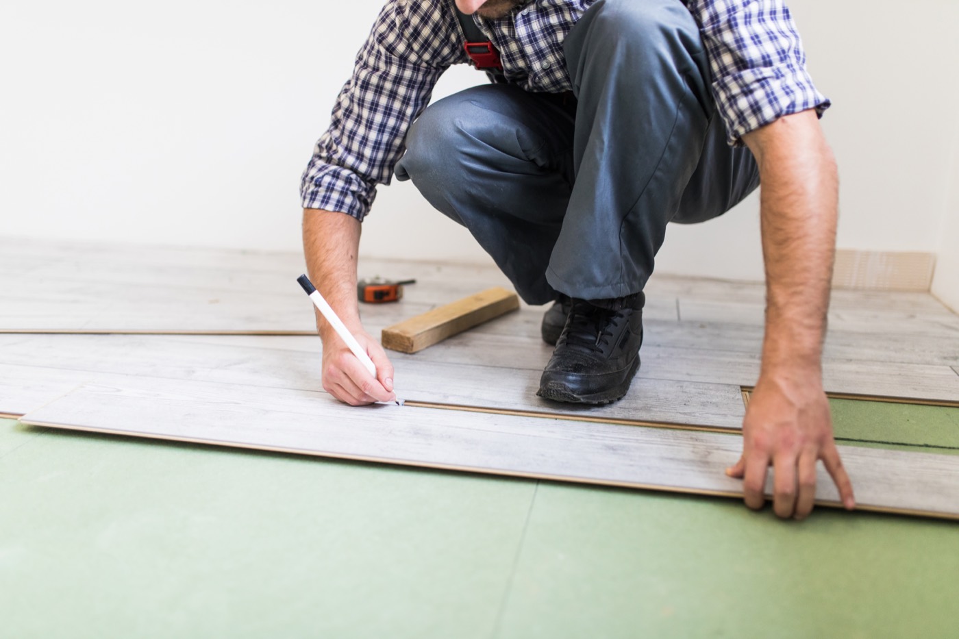 Worker installing residential plank flooring